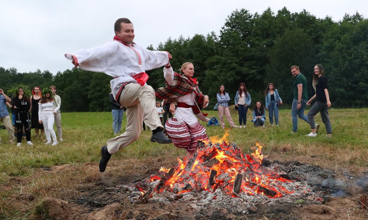 People jump over a bonfire during the celebrations of the Ivan Kupala Festival in the suburb of Minsk, Belarus, July 3, 2021. (Photo by Henadz Zhinkov/Xinhua)