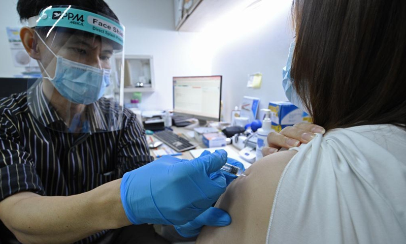 A doctor injects a woman with Sinovac COVID-19 vaccine at a private clinic in Singapore on July 6, 2021. (Photo by Then Chih Wey/Xinhua)