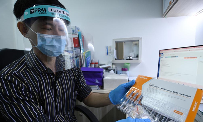 A doctor shows a box of Sinovac COVID-19 vaccines at a private clinic in Singapore on July 6, 2021. (Photo by Then Chih Wey/Xinhua)