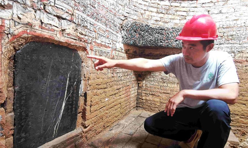 A guide introduces the fresco and characters on the wall of the tomb in Jinan, Shandong Province on July 7, 2021.Photo:China News Service