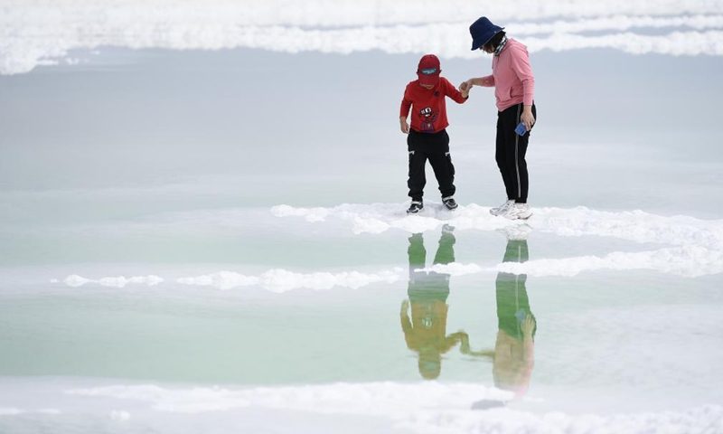 Tourists visit the Qairhan Salt Lake in northwest China's Qinghai Province, July 8, 2021. The Qairhan Salt Lake in the Qaidam Basin has been the largest potash fertilizer producing base in China. It came to exhibit its values as a tourism destination under a series of comprehensive local development schemes.Photo:Xinhua