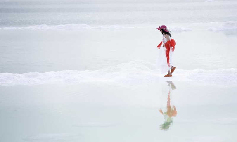 A tourist visits the Qairhan Salt Lake in northwest China's Qinghai Province, July 8, 2021. The Qairhan Salt Lake in the Qaidam Basin has been the largest potash fertilizer producing base in China. It came to exhibit its values as a tourism destination under a series of comprehensive local development schemes.Photo:Xinhua