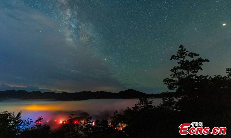 2021年7月8日，云海、星光、萤火虫飞舞将湖北国都湾镇变成童话世界。图片：中新社