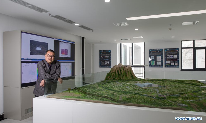 Cao Zhen, chief scientist of China's Large High Altitude Air Shower Observatory (LHAASO), poses for a photo with the sand table of LHAASO at the Institute of High Energy Physics (IHEP) under the Chinese Academy of Sciences (CAS), Feb. 23, 2021.Photo:Xinhua