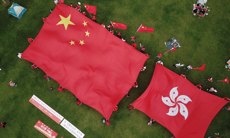 Aerial photo taken on March 6, 2021 shows citizens displaying China's national flag and the flag of the Hong Kong Special Administrative Region in support of implementing the principle of patriots administering Hong Kong at Tamar Park in Hong Kong, south China.Photo:Xinhua