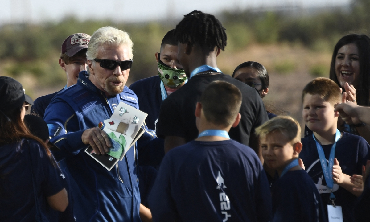Billionaire Richard Branson takes off on Sunday from a base in New Mexico aboard a Virgin Galactic vessel bound for the edge of space, a voyage he hopes will lift the nascent space tourism industry off the ground. 
Inset: Richard Branson(L) receives cards from children as he walked out of Spaceport America, near Truth and Consequences, New Mexico on Sunday. Photo: AFP