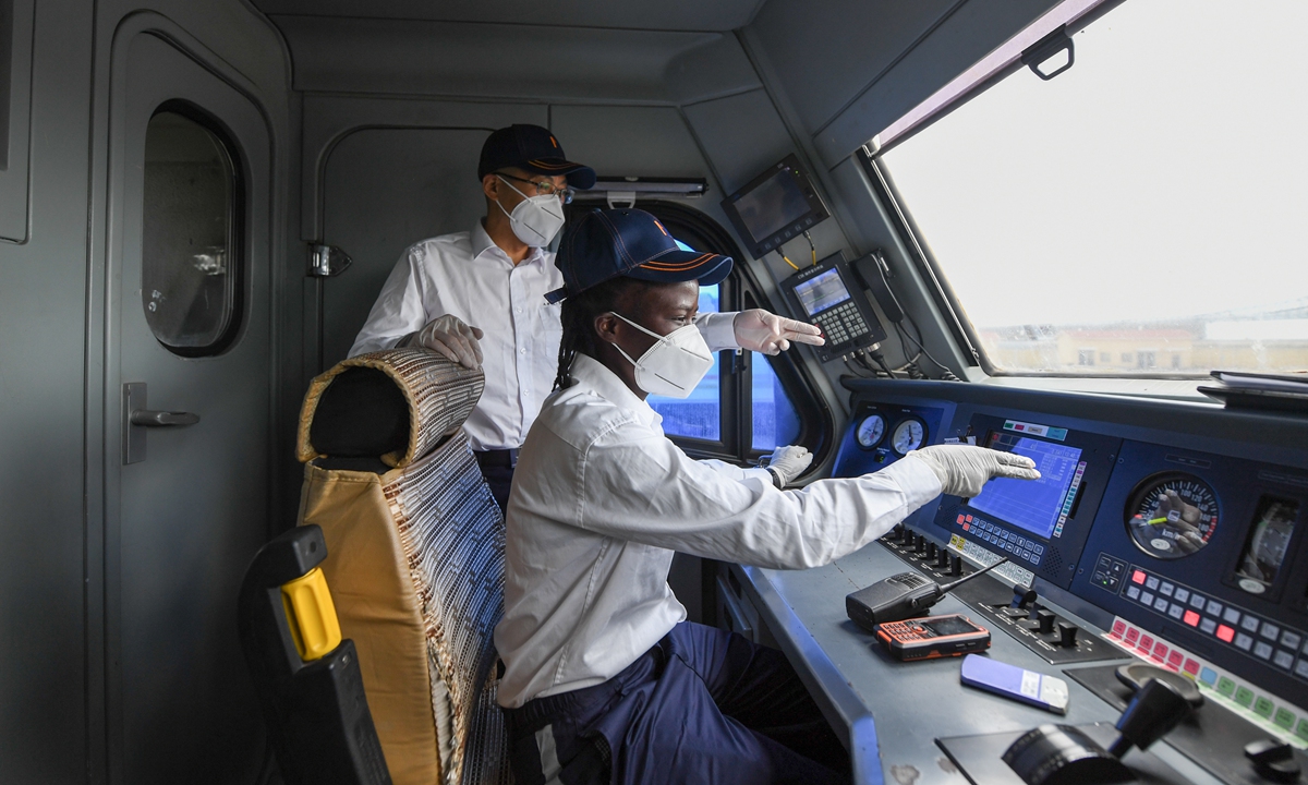 Yang Ming, a Chinese train driver of the Mombasa-Nairobi Railway, and his Kenyan apprentice check the condition of the train before its departure on Saturday. Photos: Xinhua