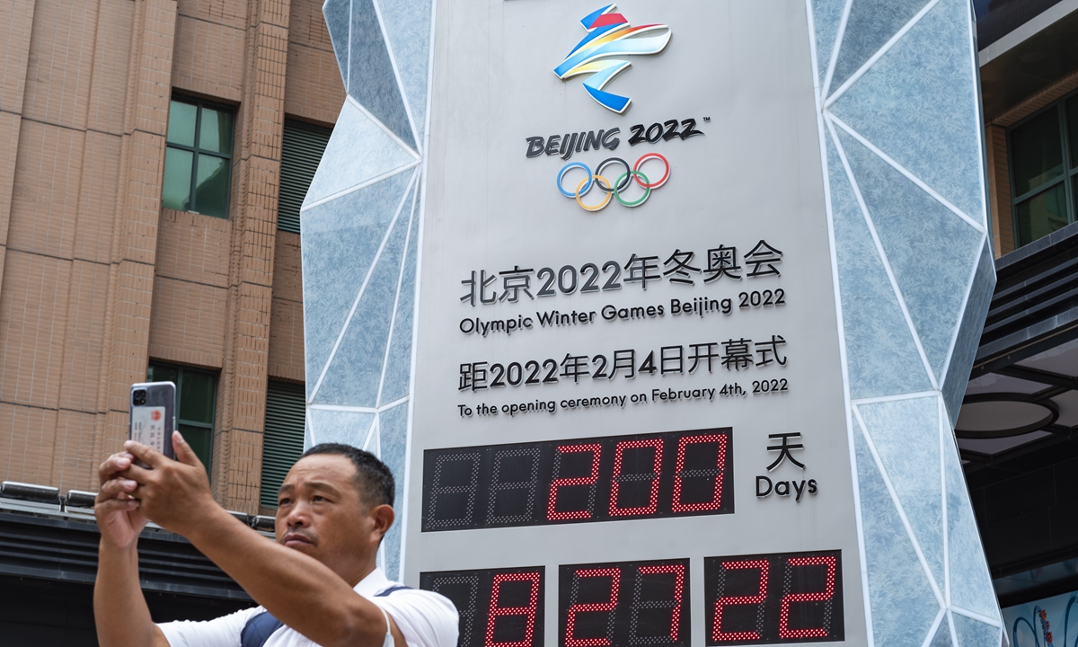 A Beijing resident takes a selfie in front of a countdown clock for the Beijing Winter Olympics 2022 on Monday, 200 days ahead of the opening of the Games, in the Wangfujing shopping street. Photo: cnsphoto