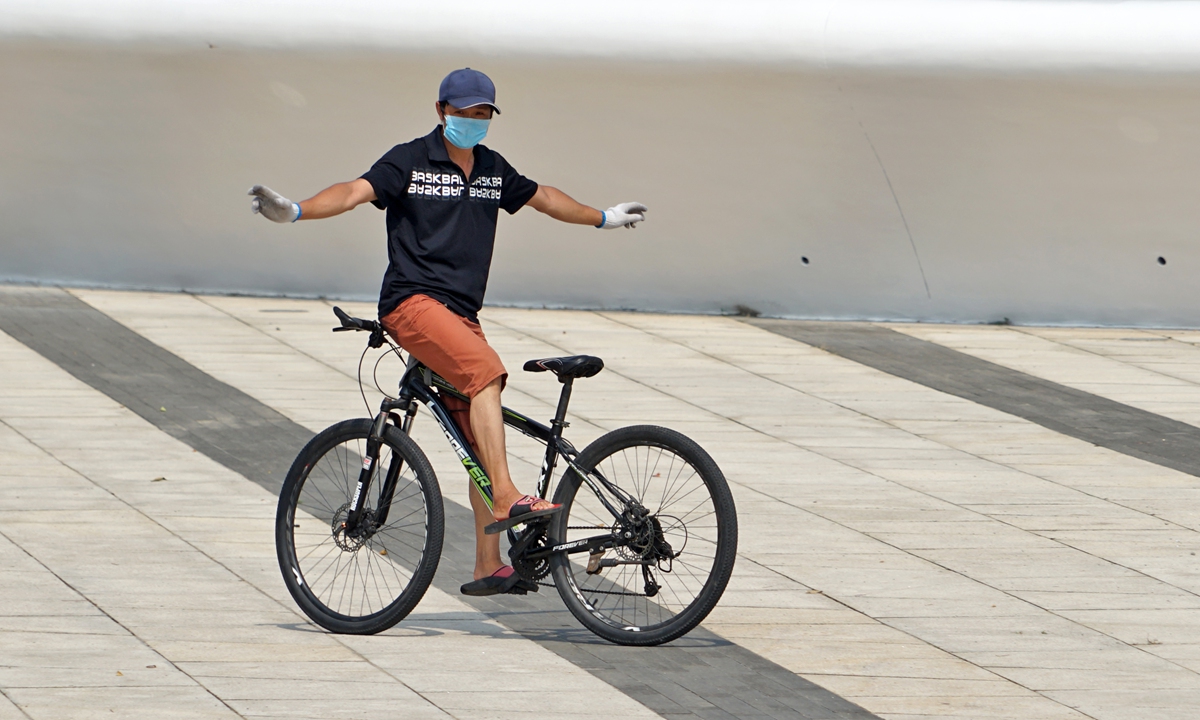 A man in Yantai, East China's Shandong Province, rides a bike backwards on Monday as an exercise. Photo: IC