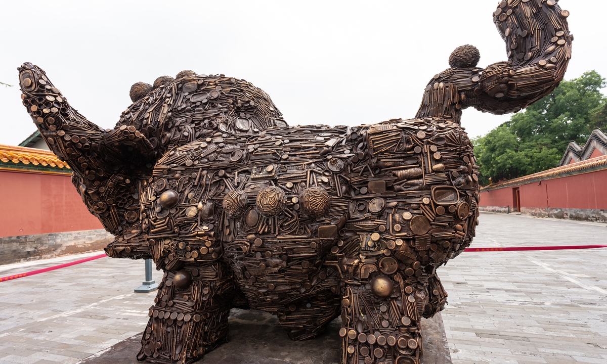 An ox sculpture made of recycled waste is shown in a 