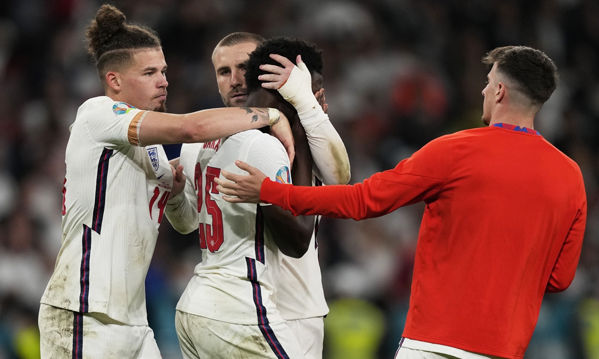 Bukayo Saka of England is consoled by teammates after the Euro 2020 final against Italy on July 11 in London, England. Photo: VCG