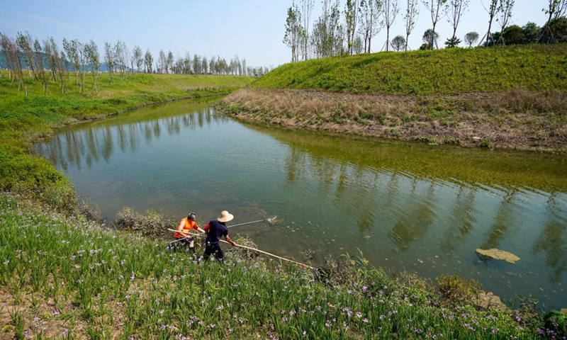 Members of a watercourse patrol team clean the Hangu section of Liangtan River in southwest China's Chongqing, July 14, 2021. The water quality and ecosystem of Liangtan River in Chongqing has been improved in recent years thanks to the city's ecological restoration efforts.Photo:Xinhua