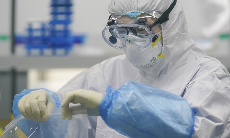 A staff member handles nucleic acid testing samples at a novel coronavirus detection lab in Wuhan, central China's Hubei Province, Feb. 22, 2020. Photo:Xinhua