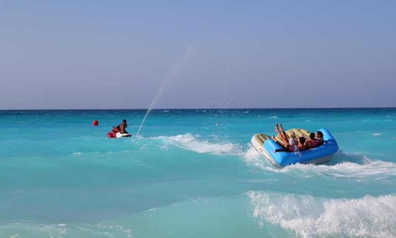 People experience water sports in El Alamein, Matrouh province, north coast of Egypt, on July 17, 2021. El Alamein is a town on the coast of the Mediterranean Sea in Egypt. It boasts silvery sandy beach and sapphire-color seawater, usually visited by many tourists every year.(Photo: Xinhua)