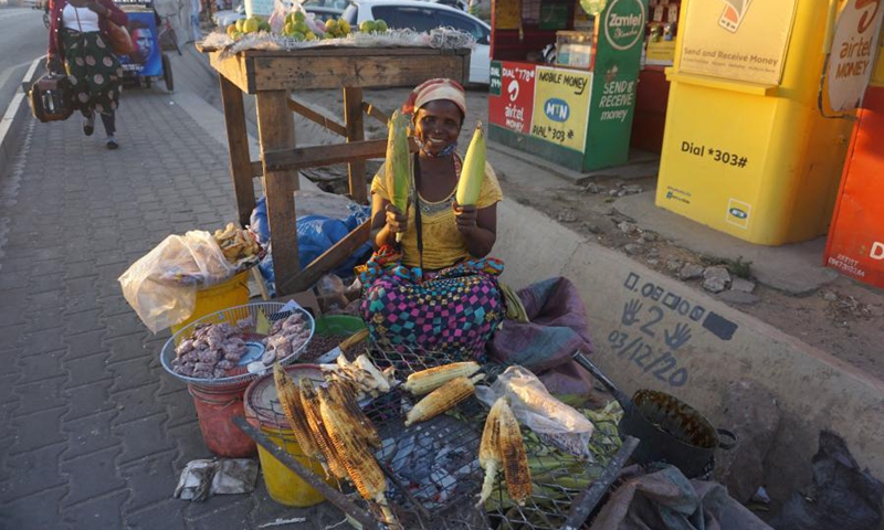 Idah Sakala, a fresh maize reseller, poses with fresh maize cobs in Lusaka, Zambia, on July 1, 2021. (Photo: Xinhua)