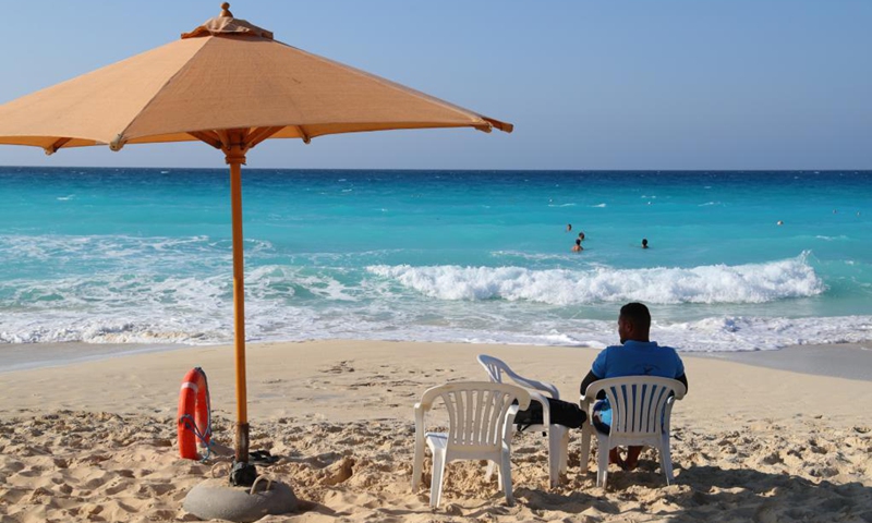 People enjoy themselves on the beach in El Alamein, Matrouh province, north coast of Egypt, on July 17, 2021. El Alamein is a town on the coast of the Mediterranean Sea in Egypt. It boasts silvery sandy beach and sapphire-color seawater, usually visited by many tourists every year.(Photo: Xinhua)