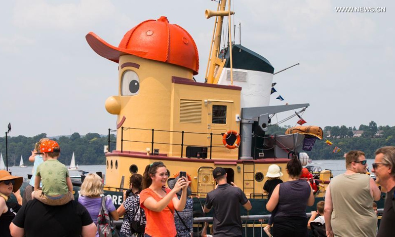 People welcome the tugboat Theodore Too upon its arrival at the Port of Hamilton in Hamilton, Ontario, Canada, on July 18, 2021. Theodore Too, a 65-foot replica of beloved children's TV character, Theodore Tugboat, arrived in Hamilton on Sunday after a journey from Halifax on a mission to promote water conservation.(Photo: Xinhua)