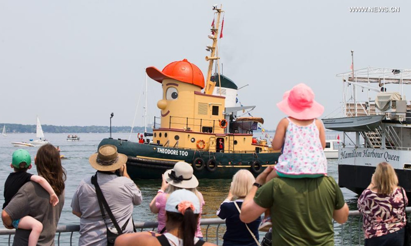 People welcome the tugboat Theodore Too upon its arrival at the Port of Hamilton in Hamilton, Ontario, Canada, on July 18, 2021. Theodore Too, a 65-foot replica of beloved children's TV character, Theodore Tugboat, arrived in Hamilton on Sunday after a journey from Halifax on a mission to promote water conservation.(Photo: Xinhua)