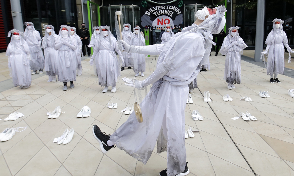 Activists from the climate protest group Extinction Rebellion carry out a performance with 26 shoes, representing the people who die from air pollution in London each day, outside the Transport For London offices in Stratford in southeast London on August 31, 2020. Photo: AFP