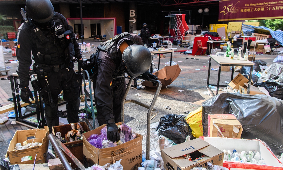 Hong Kong Police Explosive Ordnance Disposal Bureau personnel handle a Molotov cocktail as they search for explosives and chemicals on November 28, 2019 at the Hong Kong Polytechnic University occupied by rioters. Photo: AFP