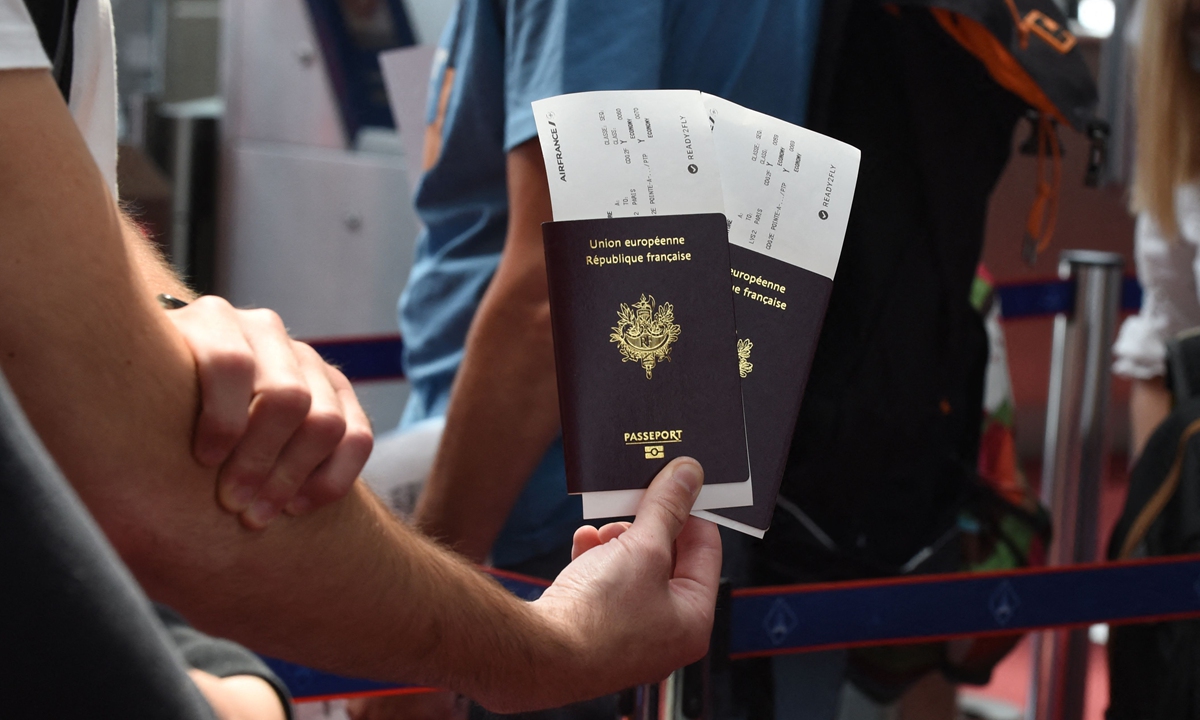 Passengers hold their passports with Air France travel documents with the 