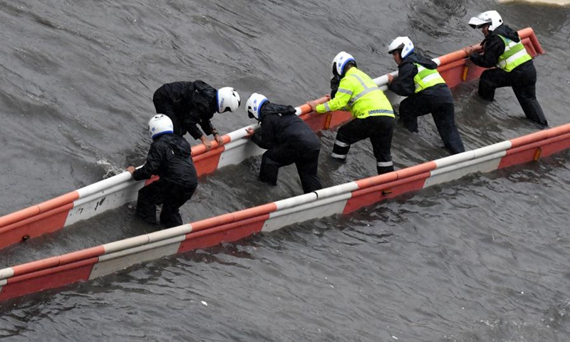 Traffic police repair road facilities in Zhengzhou, capital of central China's Henan Province, July 20, 2021.(Photo: Xinhua)