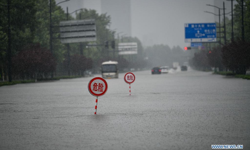 Danger signs are installed on a waterlogged road in Zhengzhou, capital of central China's Henan Province, July 20, 2021. More than 144,660 residents have been affected by torrential rains in central China's Henan Province since July 16, and 10,152 have been relocated to safe places, the provincial flood control and drought relief headquarters said Tuesday.(Photo: Xinhua)