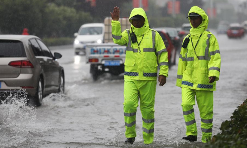Policemen direct traffic at a waterlogged area in Wuzhi County, central China's Henan Province, July 20, 2021.(Photo: Xinhua)