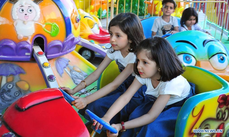 Children play at a theme park as part of the Muslim Eid al-Adha feast celebration in the capital Damascus, Syria, July 21, 2021. (Photo by Ammar Safarjalani/Xinhua)