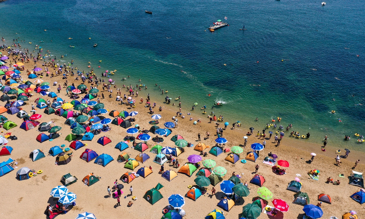 Tourists and local residents enjoy the sun at Fujiazhuang Beach in Dalian, Northeast China's Liaoning Province on Thursday. Thursday marked the Greater Heat in the 24 Chinese solar terms, the hottest season of the year in most parts of China. Photo: VCG