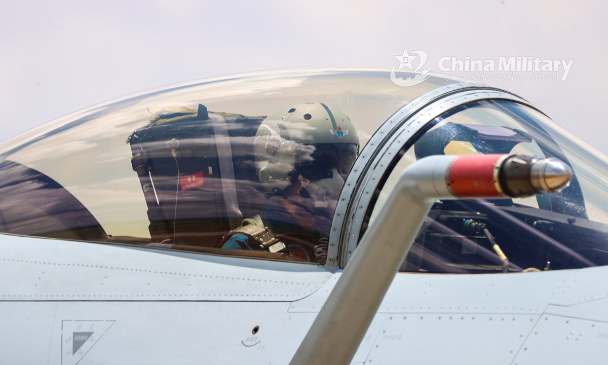 Pilots assigned to an aviation brigade under the PLA Southern Theater Command get well-prepared in their cockpit prior to a live-fire flight training exercise on July 13, 2021.Photo: China Military Online