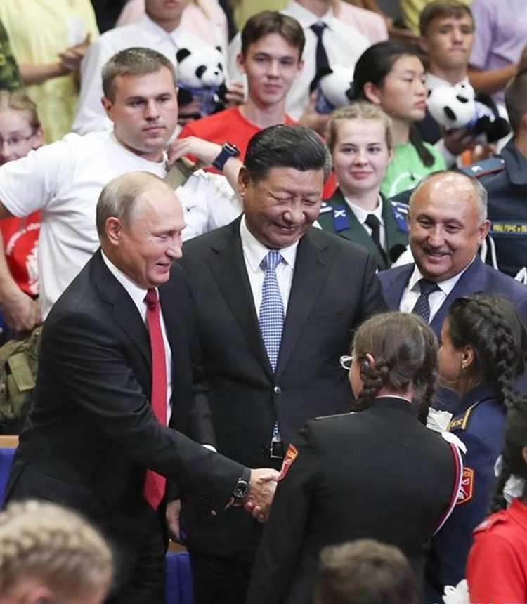 Xi Jinping and Vladimir Putin talk with the children at the 10th anniversary of the recuperation visit to All-Russian Children’s Center “Ocean” by the Chinese children from quake-stricken area of Wenchuan, 2018.