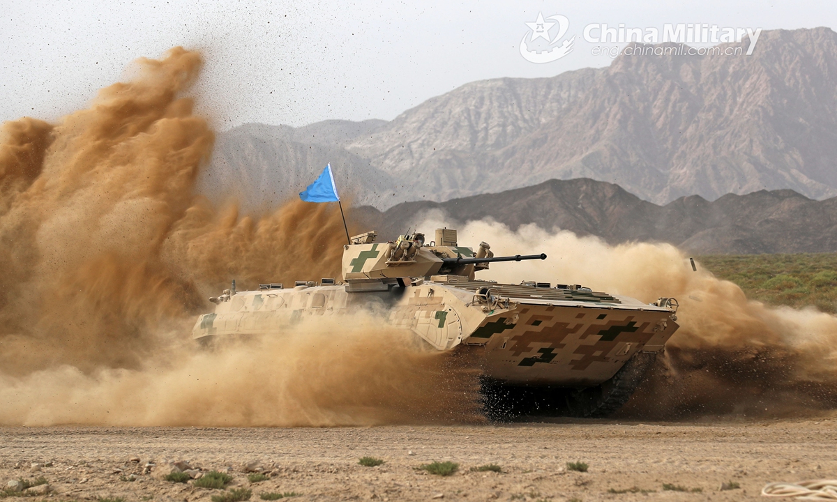 An infantry fighting vehicle (IFV) attached to a combined arms brigade under the PLA Army dashes through a mound of dust during a driving skill operation of a training exercise on July 21, 2021.Photo:China Military