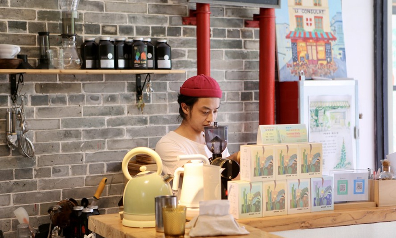 A staff member makes drinks at a store in Pantangwuyue historical community in Liwan District of Guangzhou City, south China's Guangdong Province, July 16, 2021.Photo:Xinhua