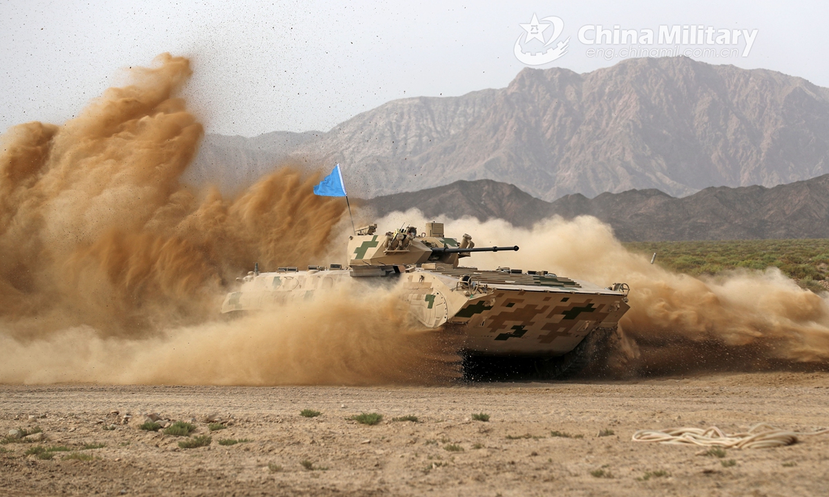 An infantry fighting vehicle (IFV) attached to a combined arms brigade under the PLA Army dashes through a mound of dust during a driving skill operation of a training exercise on July 21, 2021.Photo:China Military