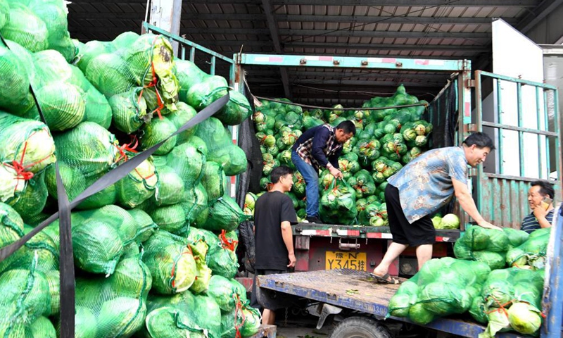 Staff members transfer vegetables at a logistic center in Zhongmu County of Zhengzhou, central China's Henan Province, July 22, 2021.Photo:Xinhua