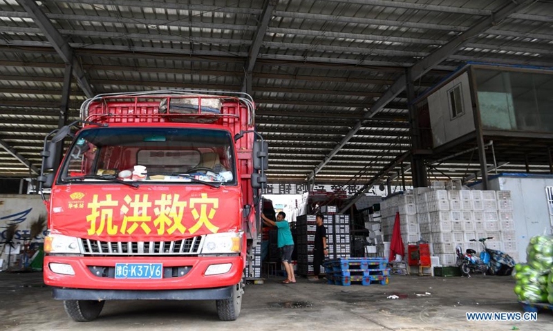People load a truck heading for flood-stricken areas with vegetables at a logistic center in Zhongmu County of Zhengzhou, central China's Henan Province, July 22, 2021.Photo:Xinhua