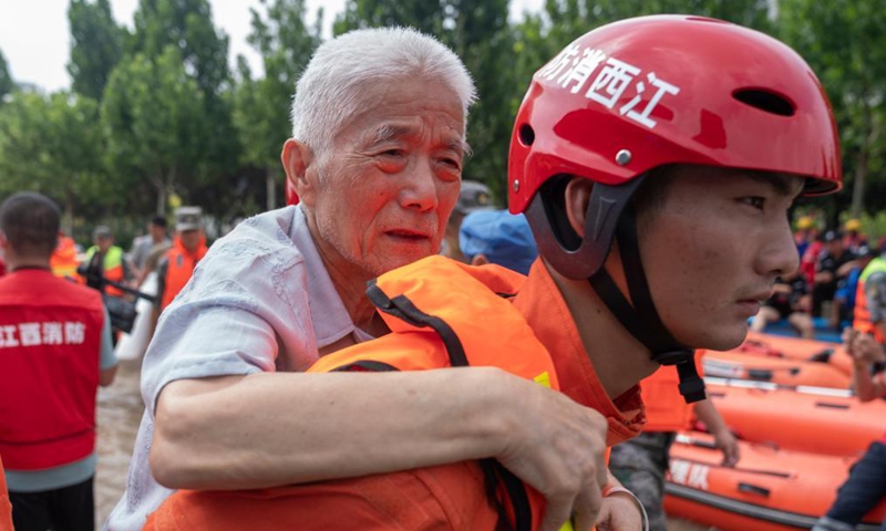Rescuers help people to evacuate near the Fuwai Central China Cardiovascular Hospital in Zhongmu County of Zhengzhou, central China's Henan Province, July 22, 2021.Photo:Xinhua