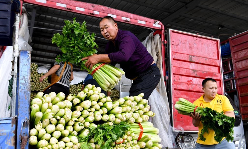 Staff members transfer vegetables at a logistic center in Zhongmu County of Zhengzhou, central China's Henan Province, July 22, 2021.Photo:Xinhua