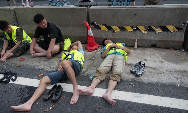 Rescuers who have been working for hours take a rest near the Fuwai Central China Cardiovascular Hospital in Zhongmu County of Zhengzhou, central China's Henan Province, July 22, 2021.Photo:Xinhua