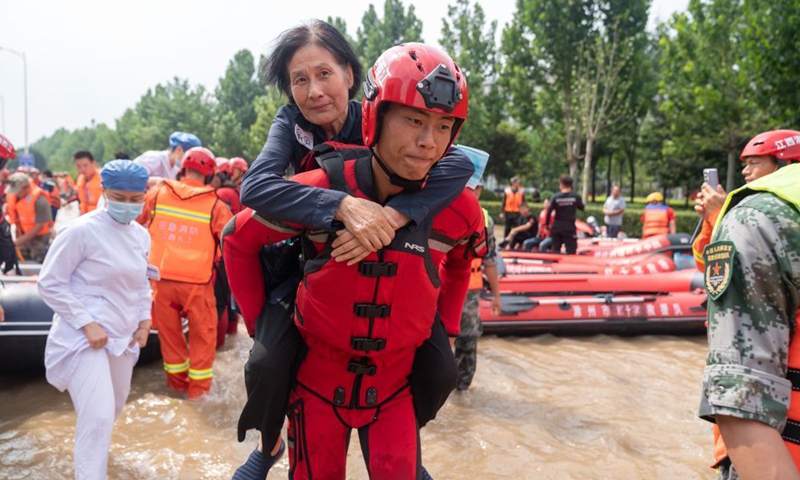 Rescuers help people to evacuate near the Fuwai Central China Cardiovascular Hospital in Zhongmu County of Zhengzhou, central China's Henan Province, July 22, 2021.Photo:Xinhua
