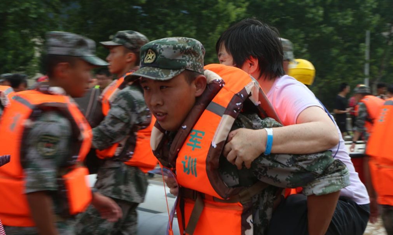 A rescuer carries a patient on his back to evacuate near the Fuwai Central China Cardiovascular Hospital in Zhongmu County of Zhengzhou, central China's Henan Province, July 22, 2021.Photo:Xinhua