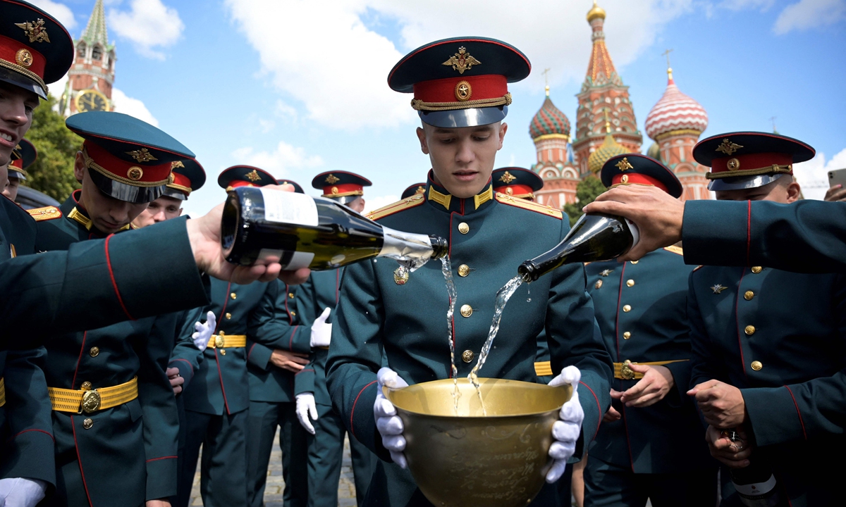 Officers pour sparkling wine into a helmet during the graduation ceremony for servicemen of Moscow Higher Military Command School in front of Saint Basil's Cathedral on Red Square in Moscow on Saturday. More than 270 graduates were awarded lieutenant's shoulder straps at the walls of The Kremlin. Photo: VCG