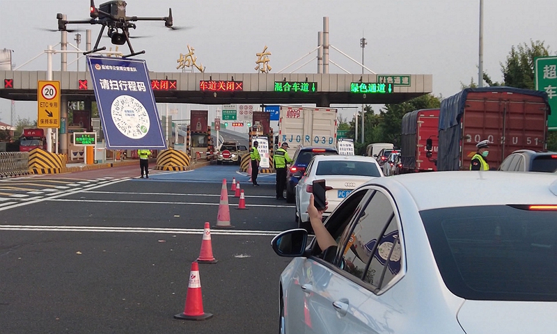 Over an exit of an expressway in Yancheng, northern Jiangsu Province, a drone is seen hovering slowly on Tuesday with a QR code hanging below, while broadcasting to drivers entering the city to scan the code that will show their travel itineraries so that they can quickly pass quarantine inspection. Photo: VCG