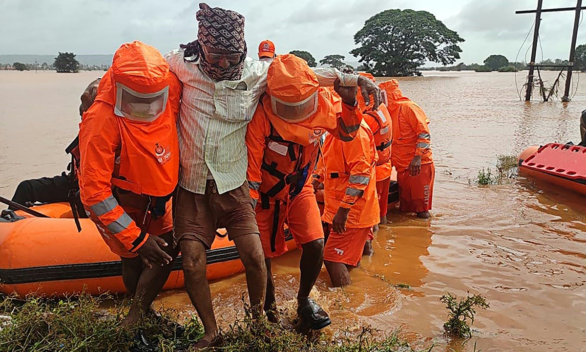 India's National Disaster Response Force personnel rescue stranded villagers from flooded areas following heavy monsoon rains in Balinge village of Kolhapur district of Maharashtra on Sunday. Photo: AFP