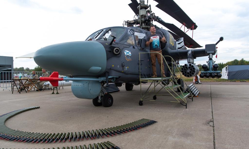 A visitor poses for a photo with the Ka-52K attack helicopter during the closing day of the International Aviation and Space Salon (MAKS)-2021 in a Moscow suburb, Russia, on July 25, 2021.(Photo: Xinhua)