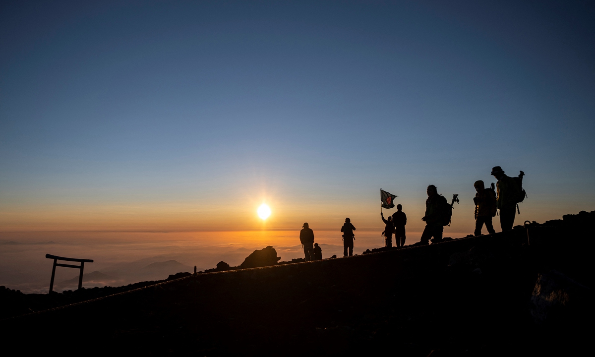 Hikers watch the sunrise from the summit of Mount Fuji on July 19. Photo: VCG
