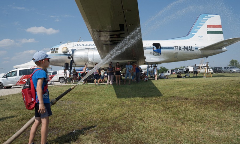 A boy sprays water during a fire truck demonstration at the Aeropark open-air aviation museum in Budapest, Hungary on July 24, 2021.(Photo: Xinhua)