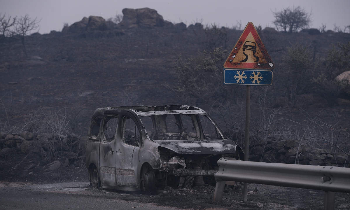 A car is left destroyed by the blaze that has raced through thousands of hectares of land on Sunday in the province of Oristano in Sardinia, Italy. Photo: VCG.