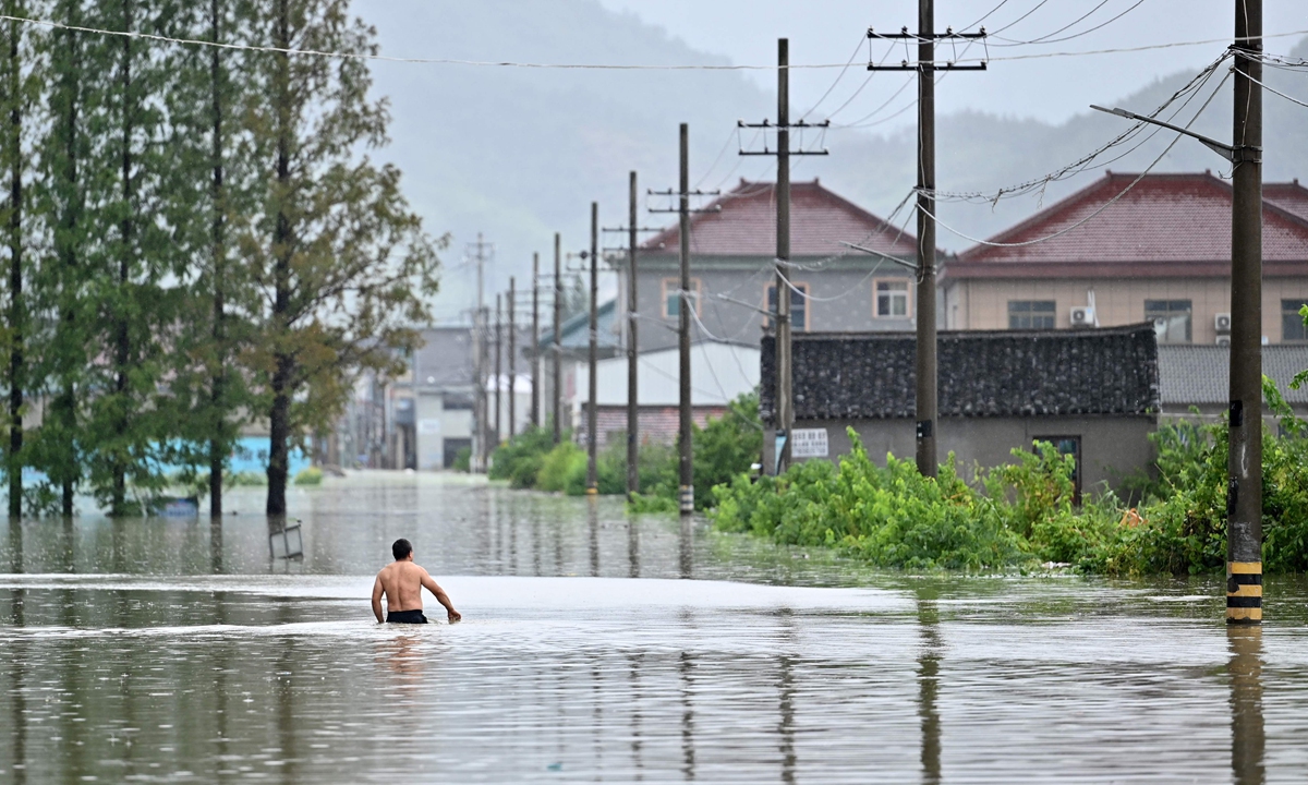A man walks in floodwaters caused by typhoon In-fa on Monday in Yuyao, East China's Zhejiang Province. The typhoon made its second landfall in Zhejiang on Monday morning after bringing rainstorms to the region over the past few days. Photo: VCG